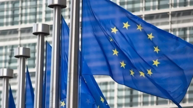 Flagi Unii Europejskiej przy temacie DMA, AirPlay i Google Cast w iPhonie